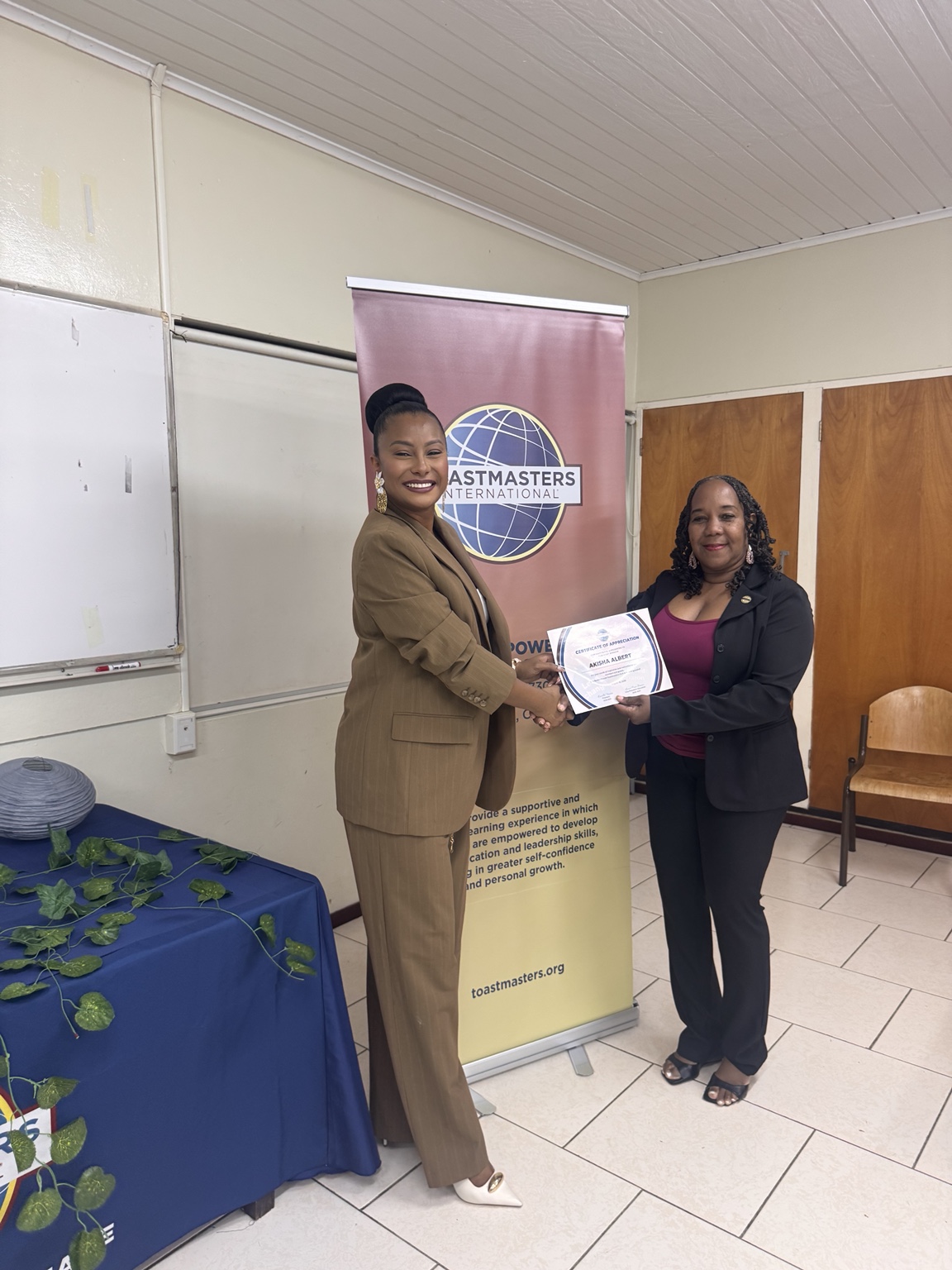Akisha Albert receiving a certificate of appreciation
